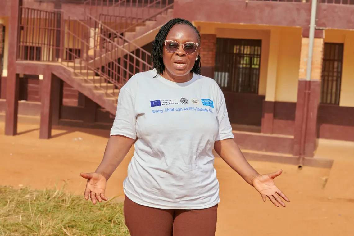 Madam Mukum standing at CBCHS a TLS Facilitator at Mulang 1