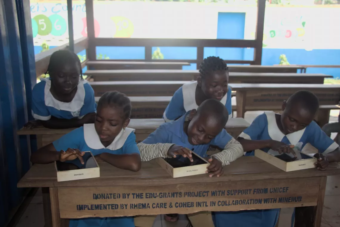 pupils manipulating digital tablets at Melong public school.