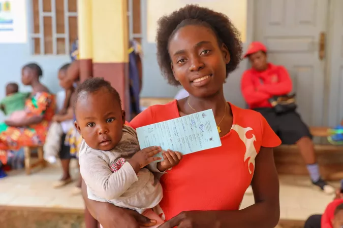 mother bearing her child after malaria vaccination
