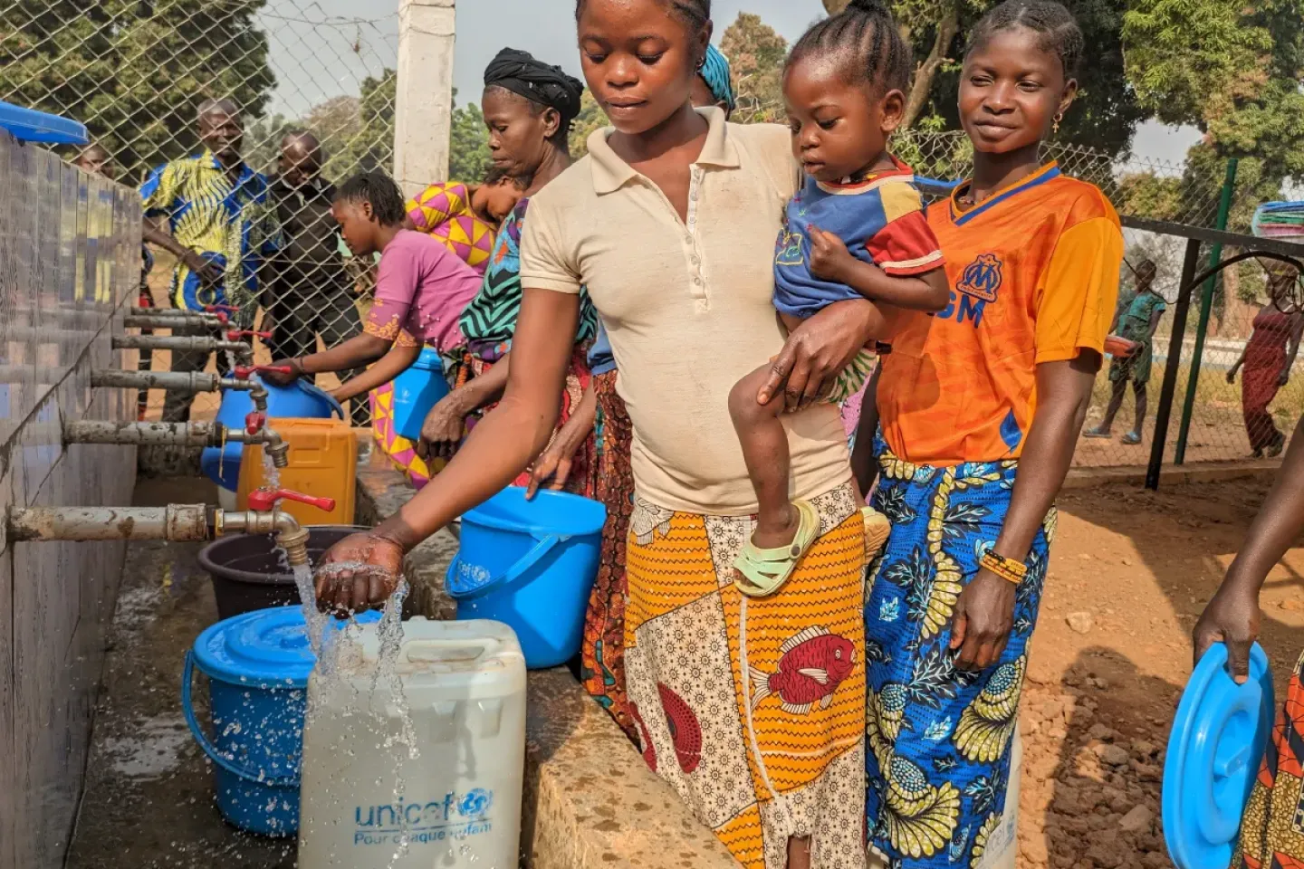 Benon Lijo joins other women from Batangafo, in the Central African Republic, to draw water flowing from the taps recently installed at the town&rsquo;s Camp Chic neighbourhood