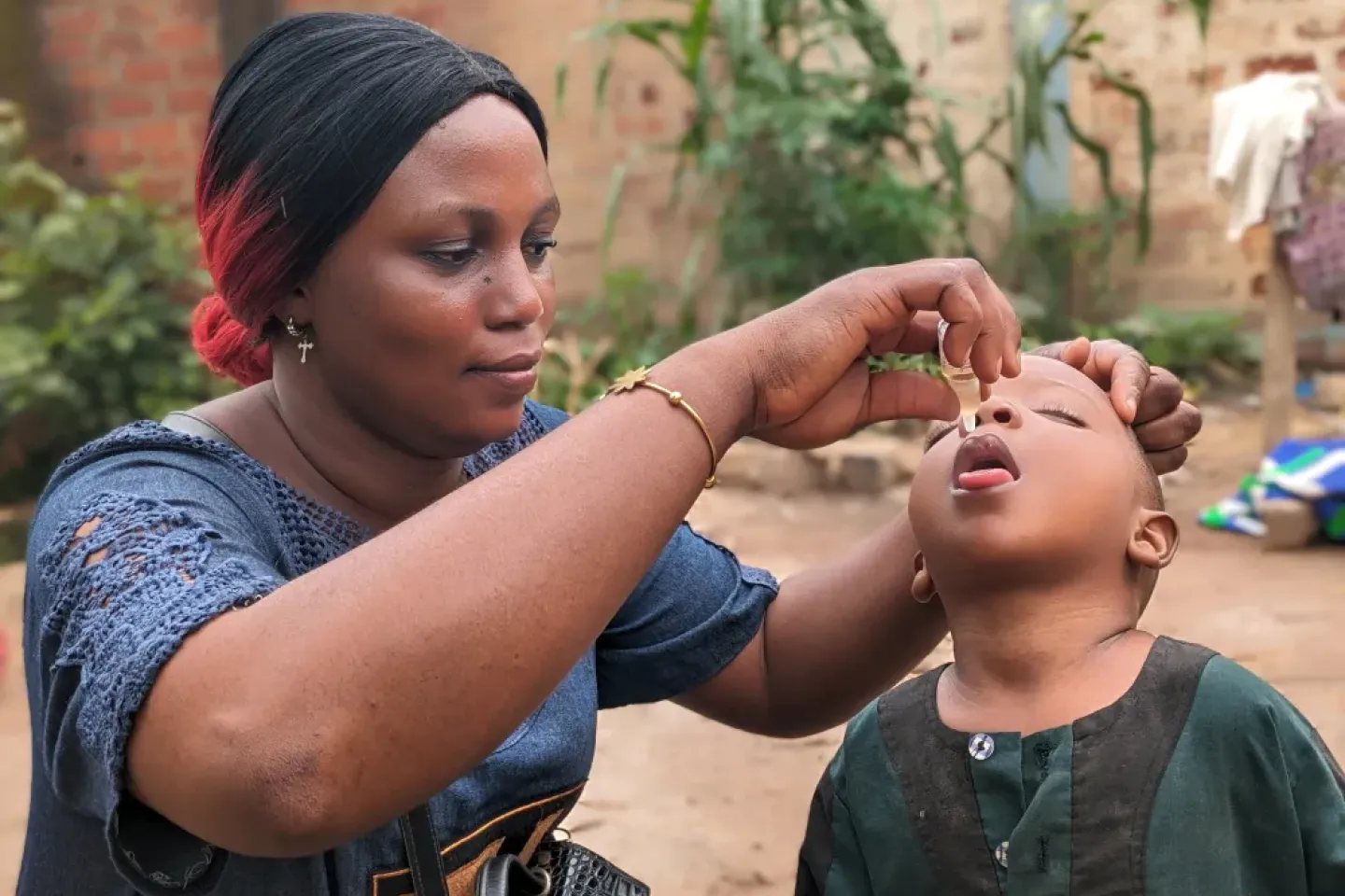 Merveille Bembe, vaccinatrice b&eacute;n&eacute;vole &agrave; Bangui, vaccine un enfant contre la polio