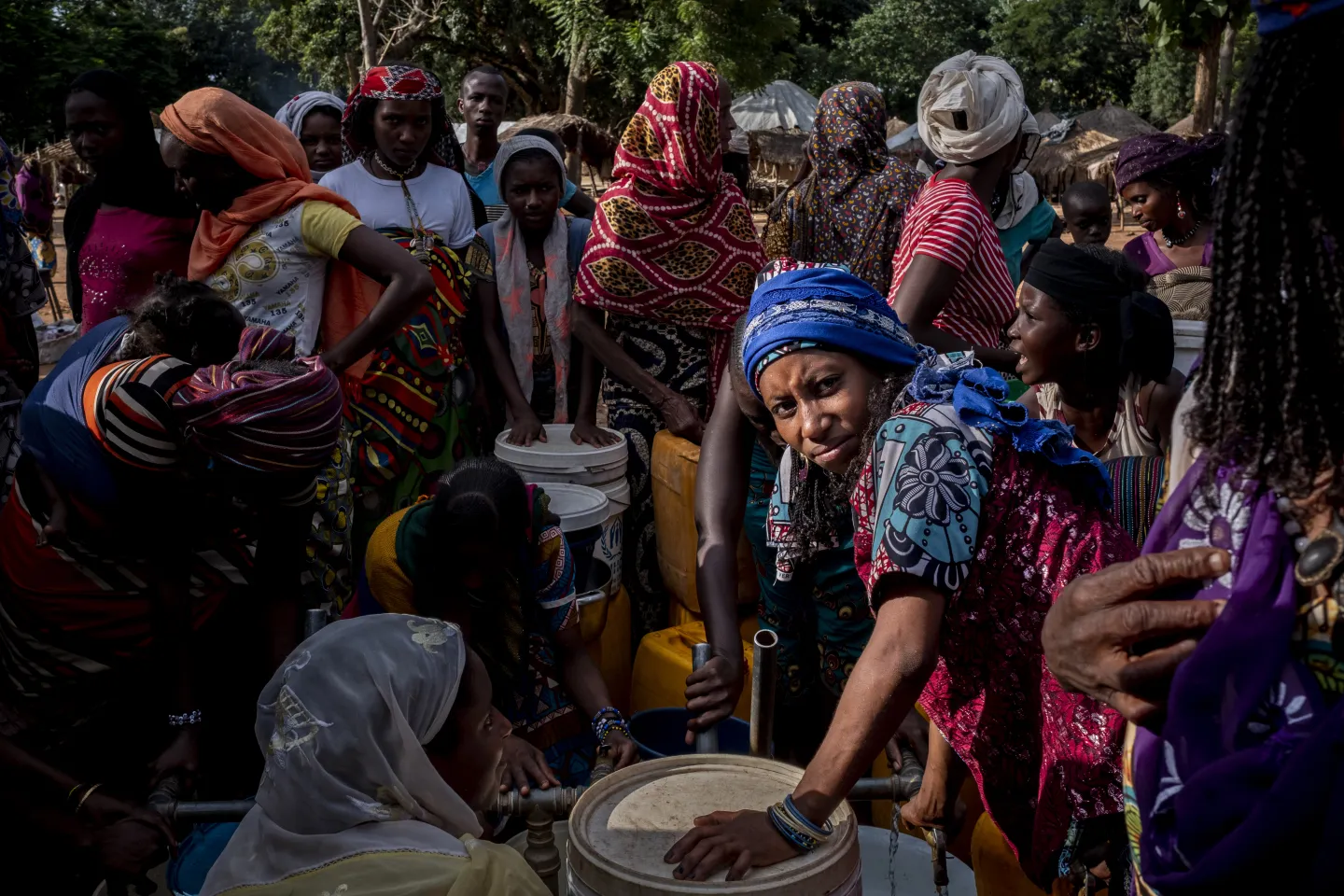 Internally displaced people gather water from a bladder provided by UNICEF at Elevage camp in Bambari