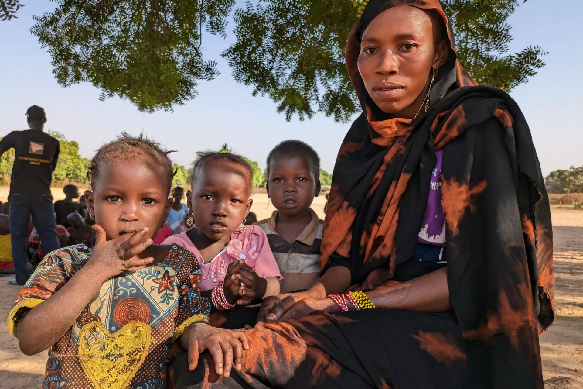 Fatima, a Sudanese refugee in Birao, sits under a tree with three of her children.