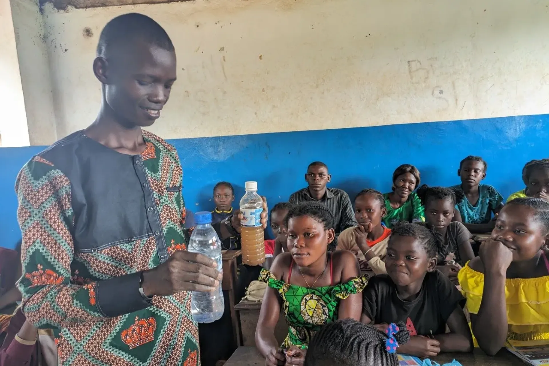Esdras Samba, a teacher at Sibut Prefectoral School, conducts a practical lesson about the importance of clean water