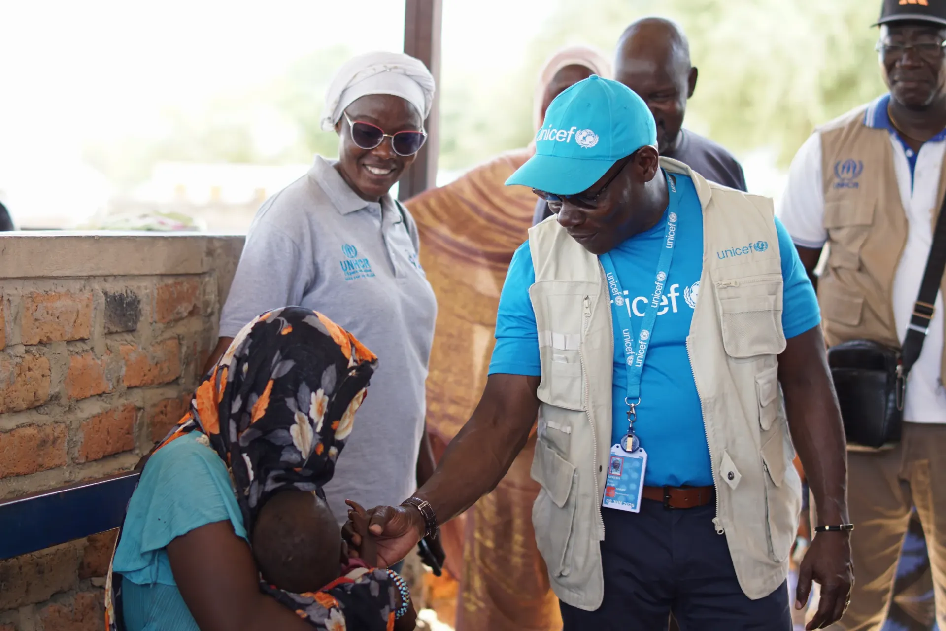 A UNICEF staff member meets a mother and child