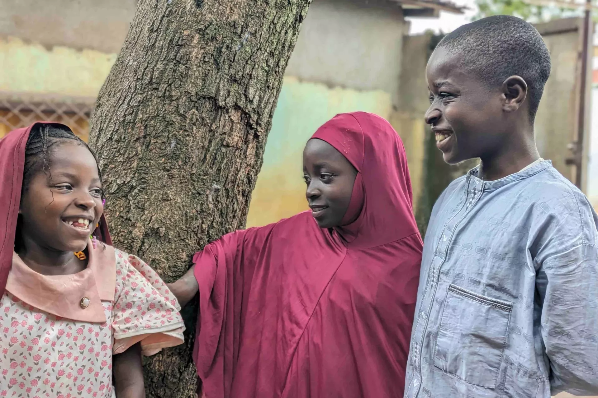 Adama, Fatou et Issa partagent un moment de d&eacute;tente dans la cour de leur maison &agrave; Bangui