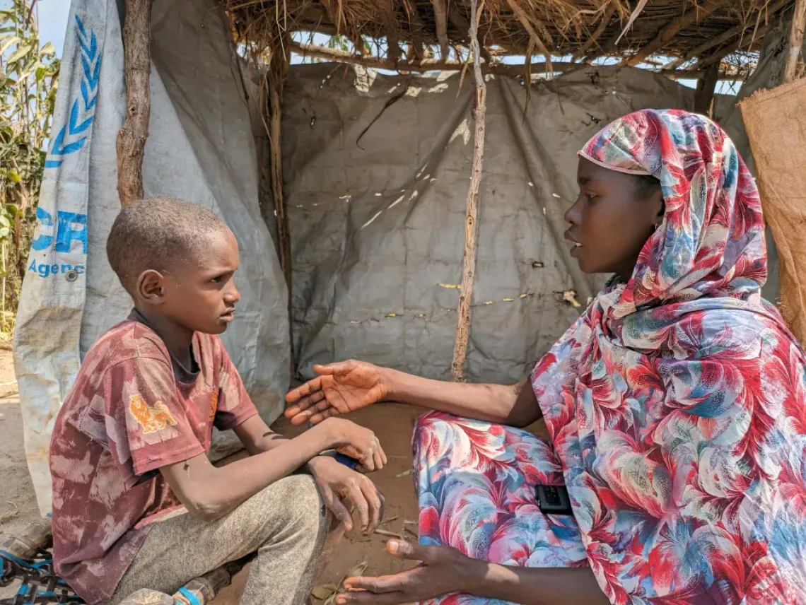 Hawa Abdsallah, a RECOPE community social worker, counsels 10-year-old Ousman