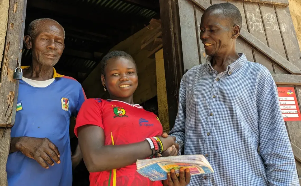 Elys&eacute;e Ndorate pose avec sa fille Belya, en compagnie d'un des enseignants b&eacute;n&eacute;voles de l'&eacute;cole. 