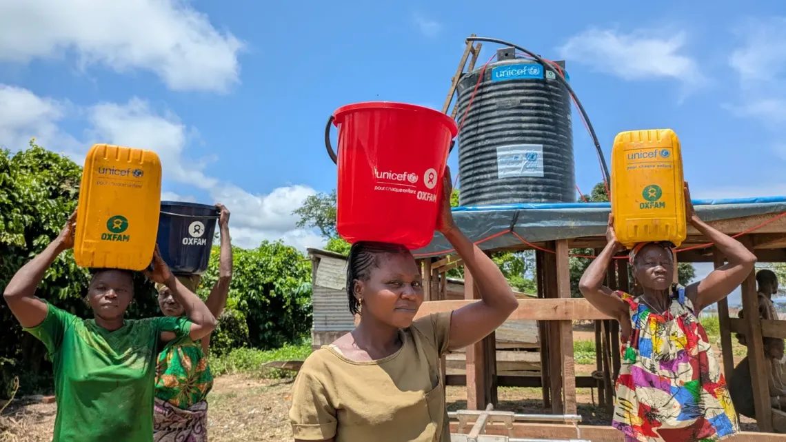 Mirabelle Opangdone is happy to see the new clean water collection point in Wayambo village.  