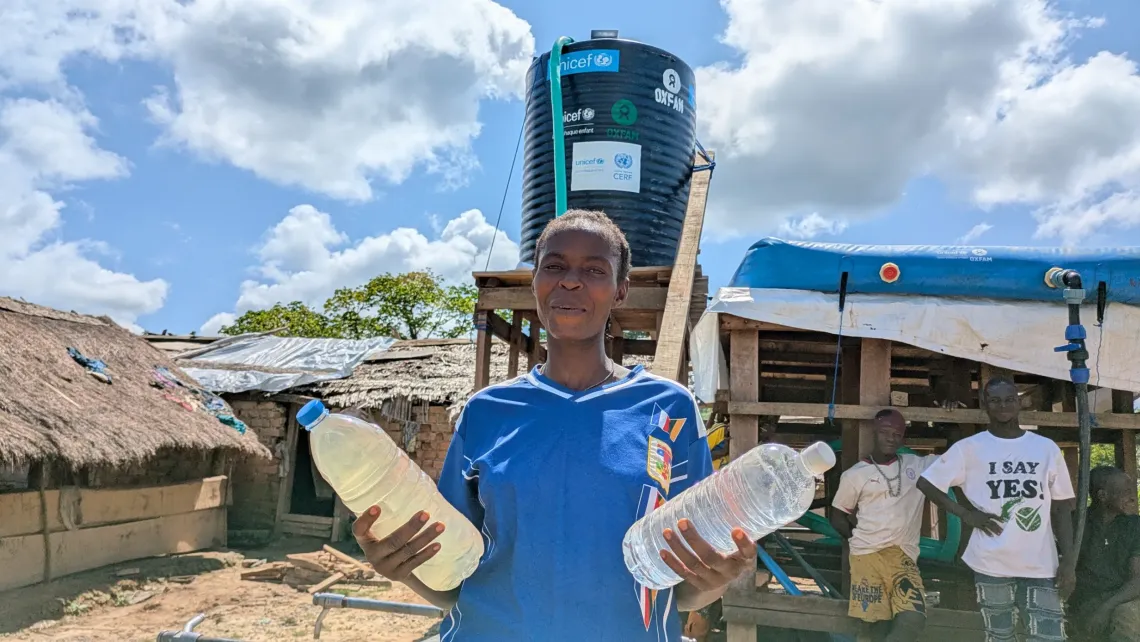 Nad&egrave;ge Ngambaou shows the difference between water from the river and water purified by a system recently installed in her village.