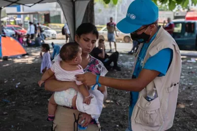 Un joven con un ni&ntilde;o migrante