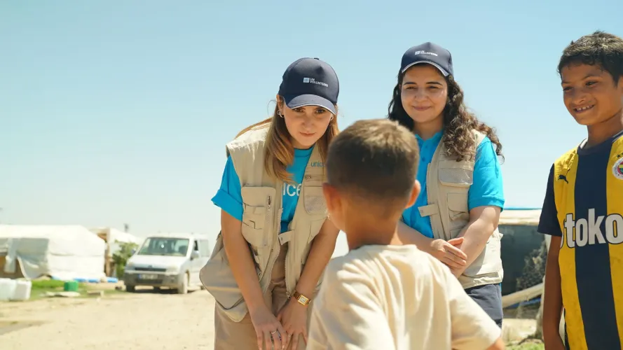 Two UN Volunteers talk to the child 