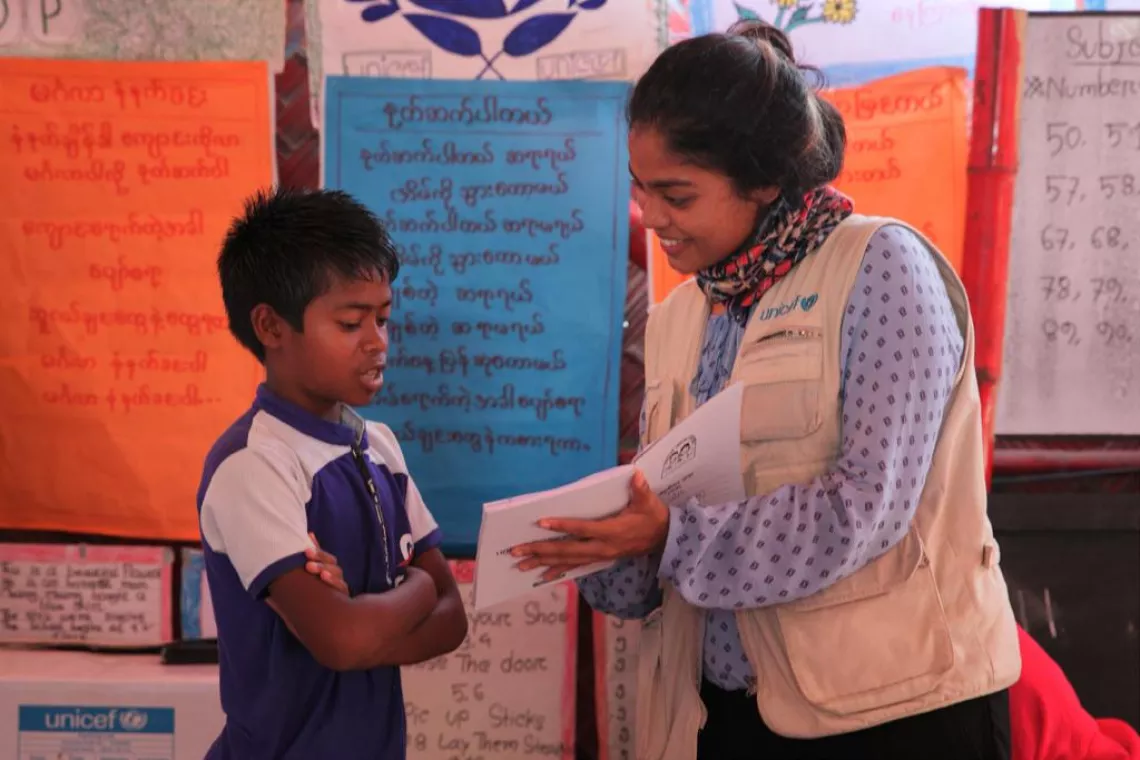 A UNICEF Staff Member teaching a boy