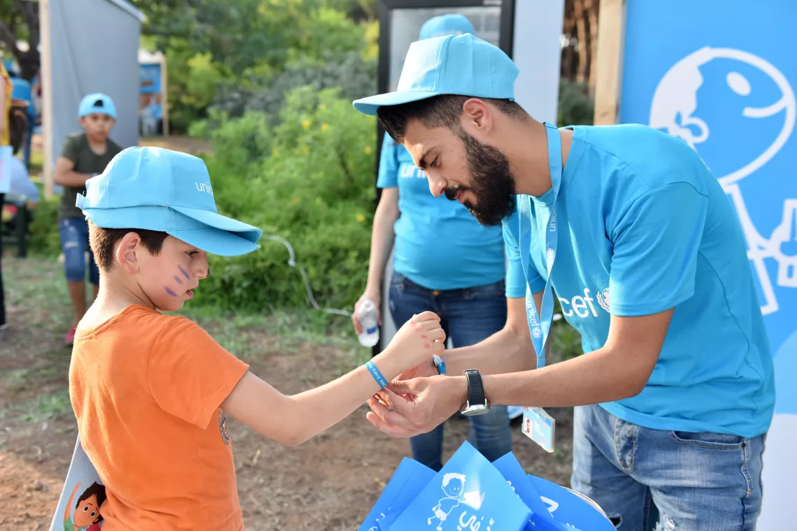 Photo of Khaled in the field playing with children