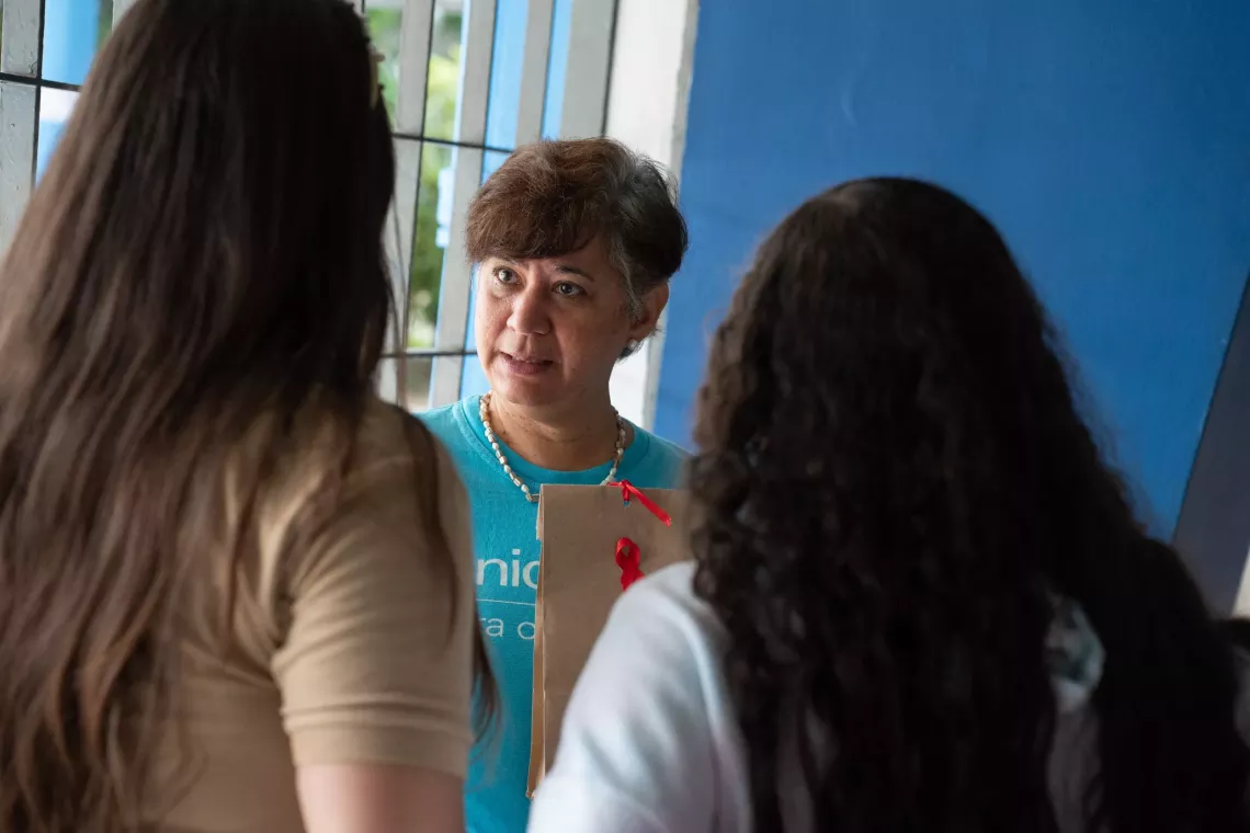 Woman wearing UNICEF t-shirt talks with young women