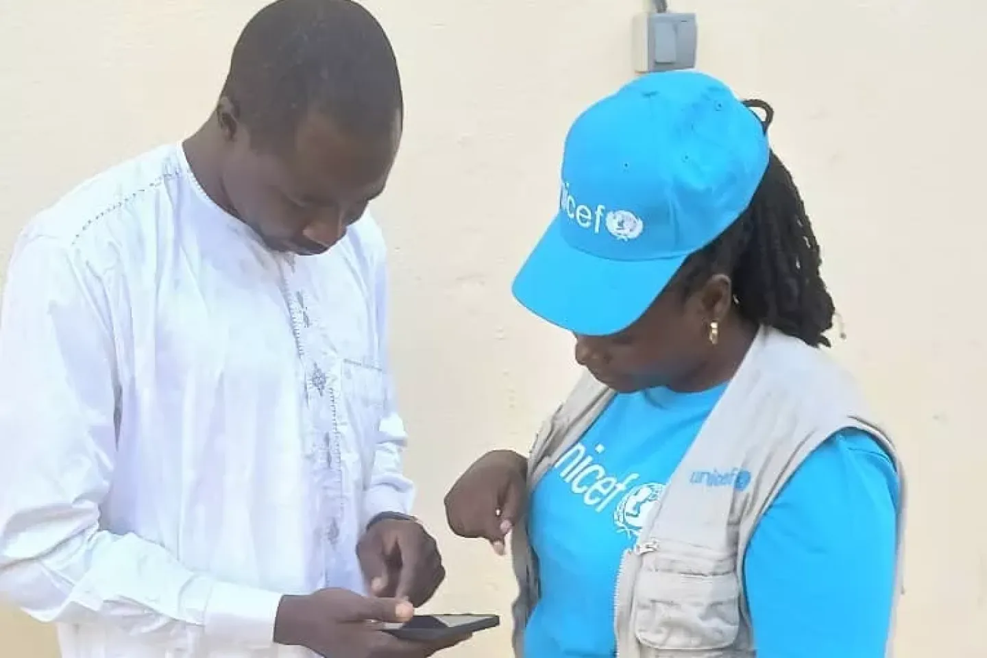 Un staff de l'UNICEF pr&eacute;sente un outil &agrave; un agent de sant&eacute;