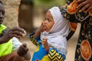 Amahani, 2 years old, receives a polio vaccine, a dose of vitamin A, and an albendazole tablet for deworming.