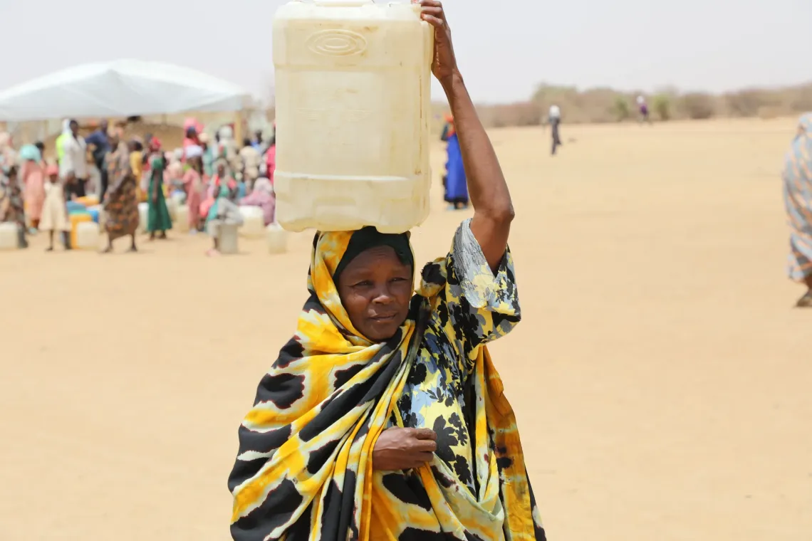 Hach&eacute; retourne chez elle avec son bidon d'eau pour les besoins de sa famille.