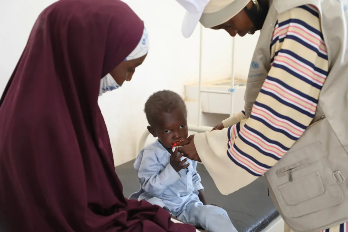 Mahamat undergoes an appetite test using a sachet of ready-to-use therapeutic food (RUTF) to determine whether he can be treated at home or requires hospitalization.