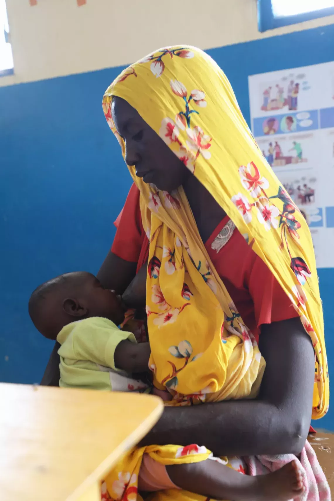 Mariam tient tendrement son petit-fils dans ses bras.