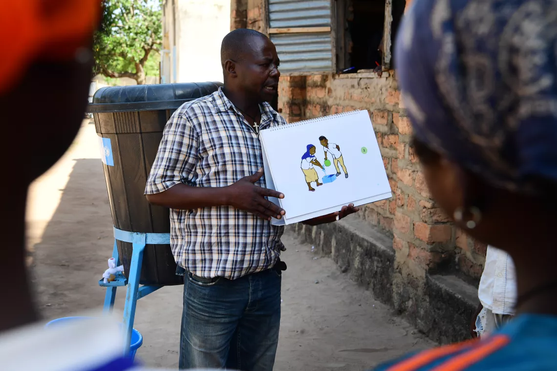 A teacher with a picture box, explaining his pupils what hygiene and sanitation is.