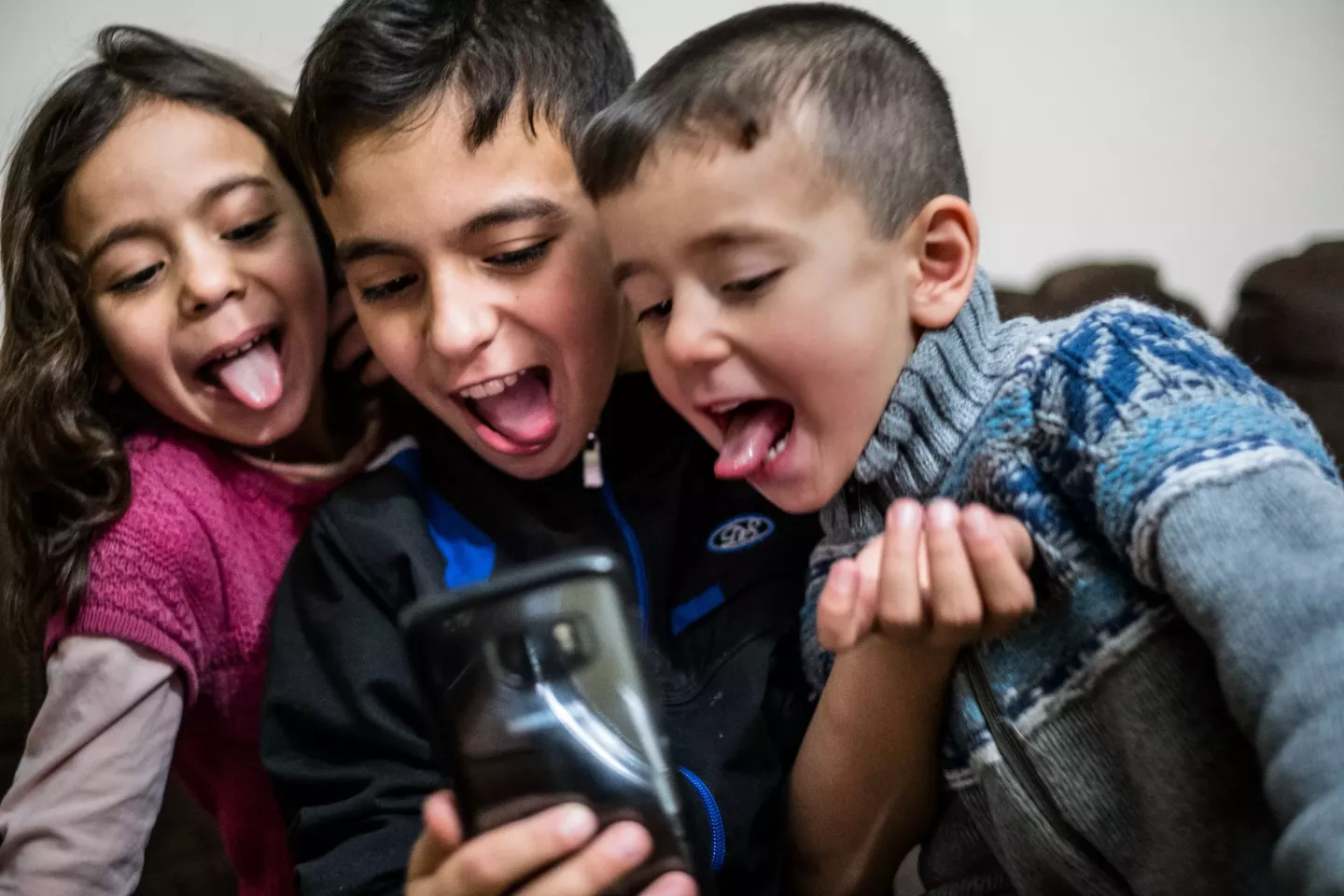 Children smiling and seeing the phone.