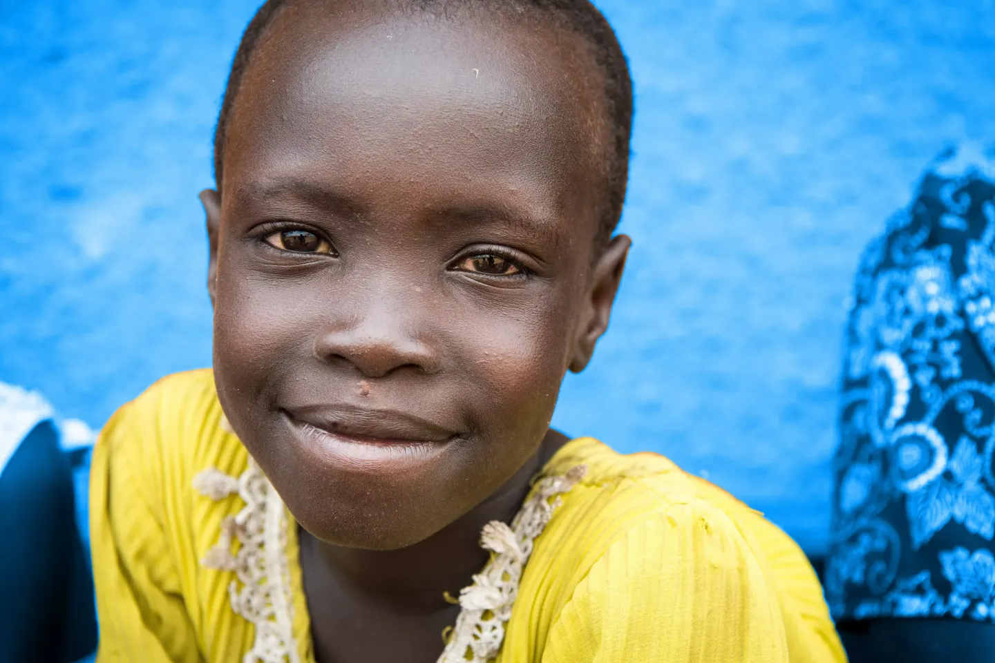 Anna Kuluma, age 5, from the village of Udu, South Sudan, awaits registration with her family at the UNHCR arrivals center in Nimule, Uganda.