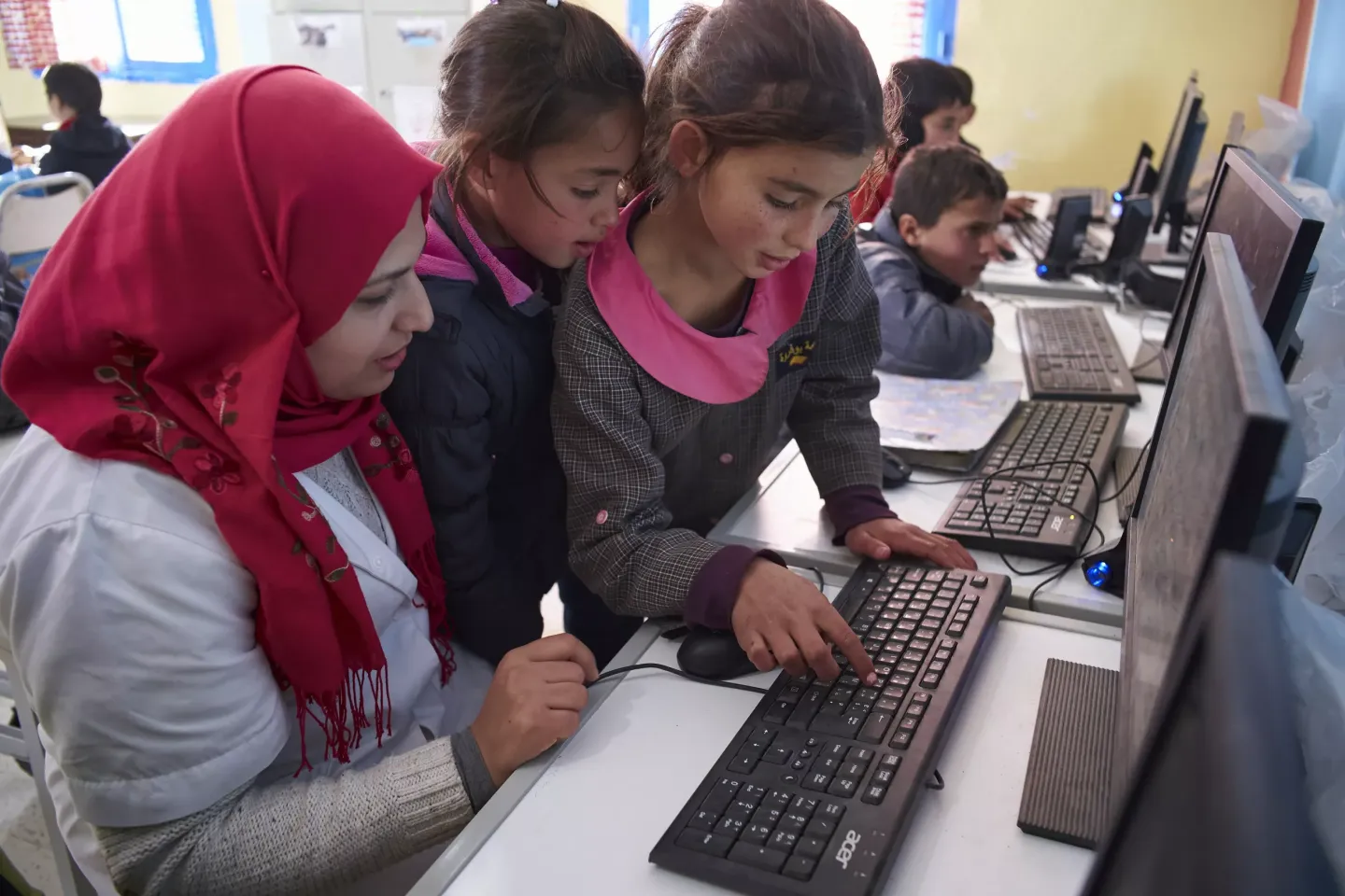 A female teacher helps children use computers in a library at Boufaroua Primary School on the outskirts of Sbeitla in Tunisia.