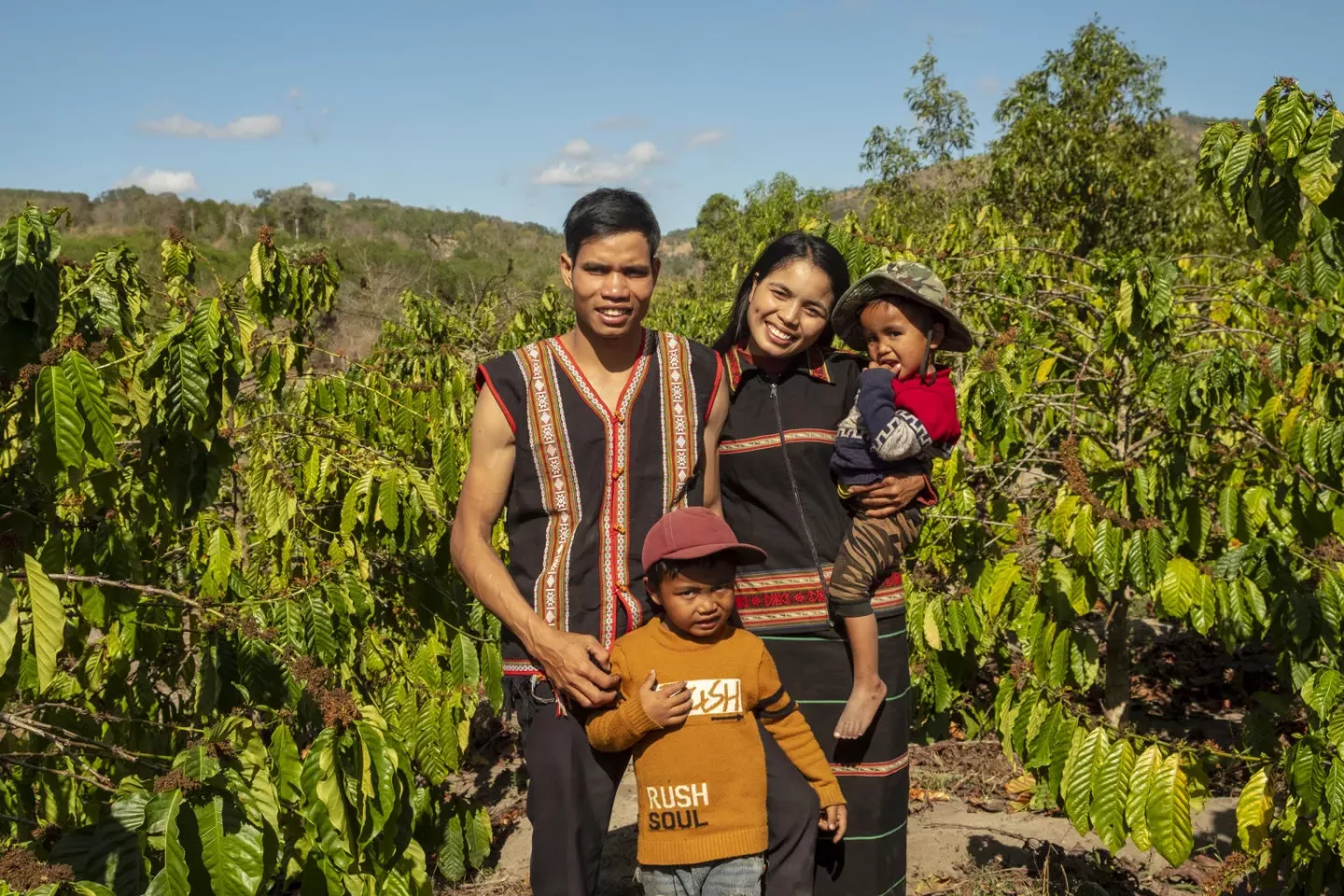 Gia Lai, in the Central Highlands region of Viet Nam, brothers Khun, 6, and A Khin, 3, pose for a portrait with their parents, father Trun and mother Nu, in the family's coffee field.