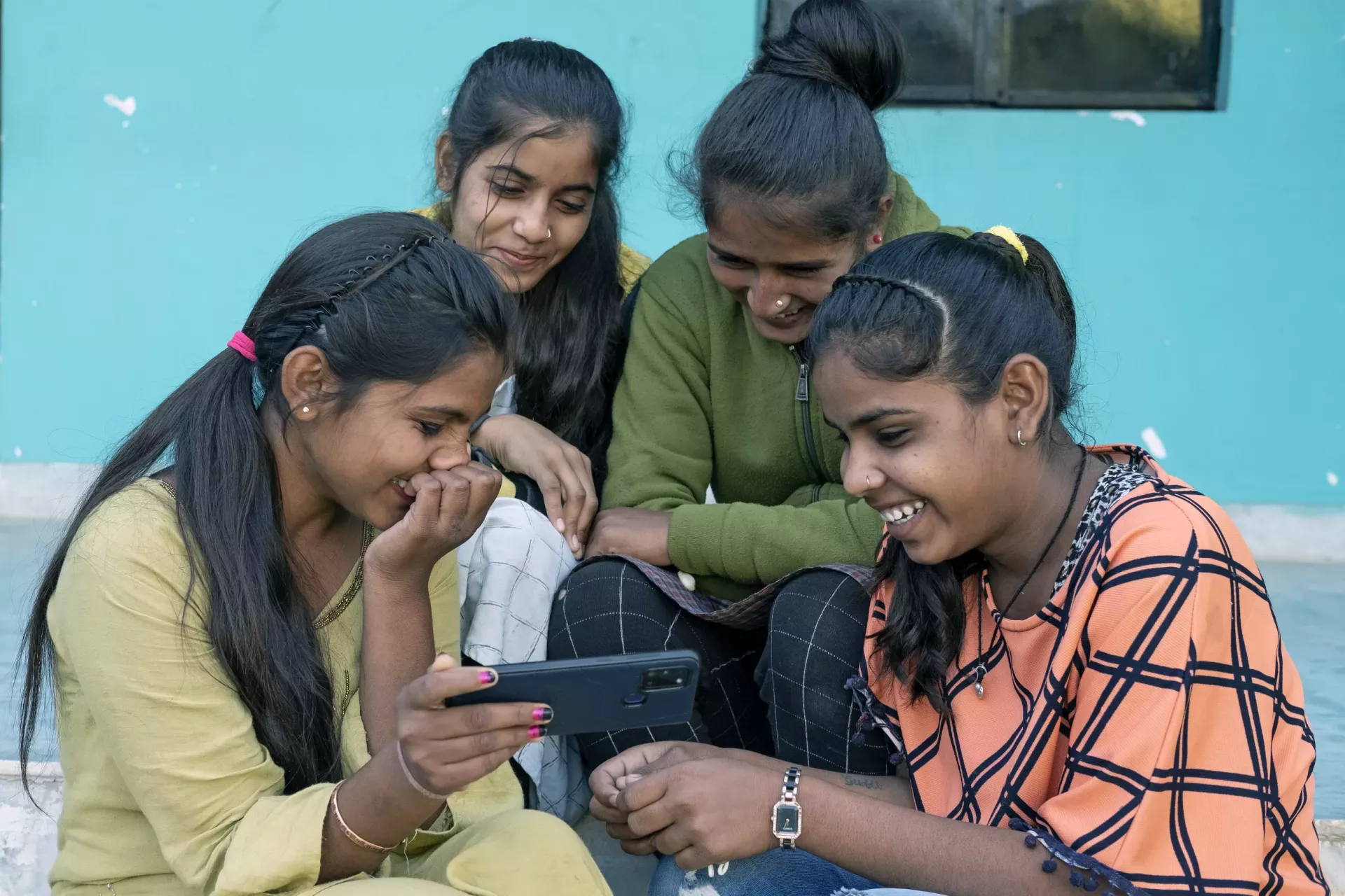 Students of J.R. Orphanage watch Bollywood comedy on a smartphone