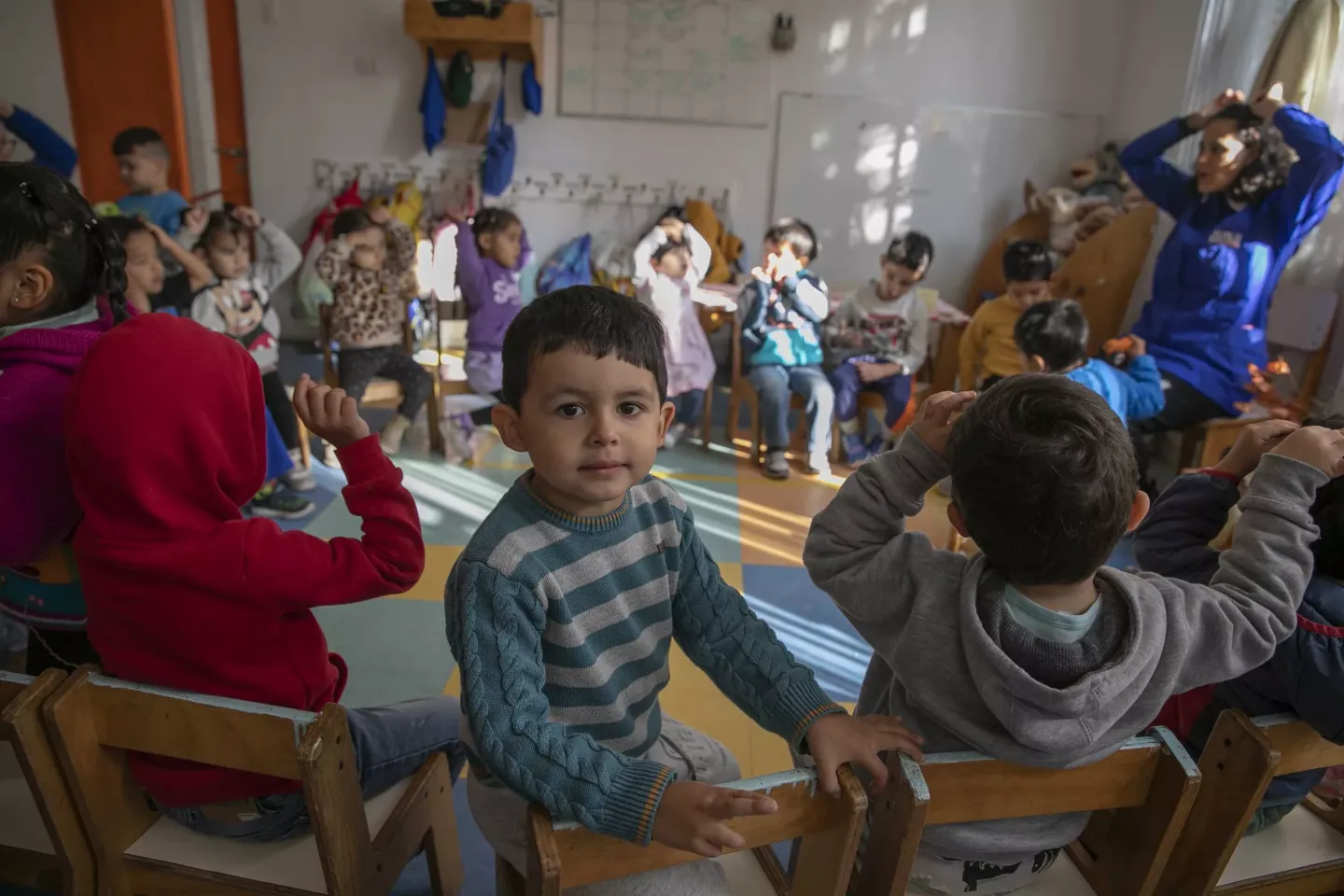 Ni&ntilde;o mira a c&aacute;mara en medio de una sala de clases
