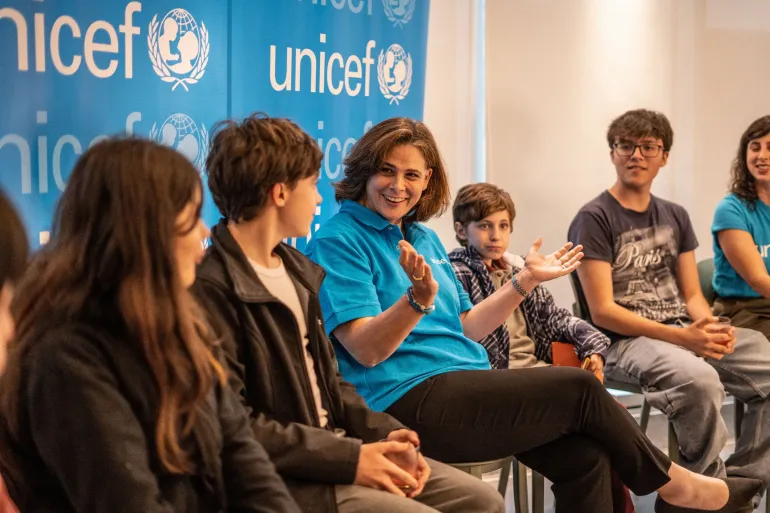 Trabajadora de UNICEF conversa con un grupo de ni&ntilde;os, ni&ntilde;as y adolescentes