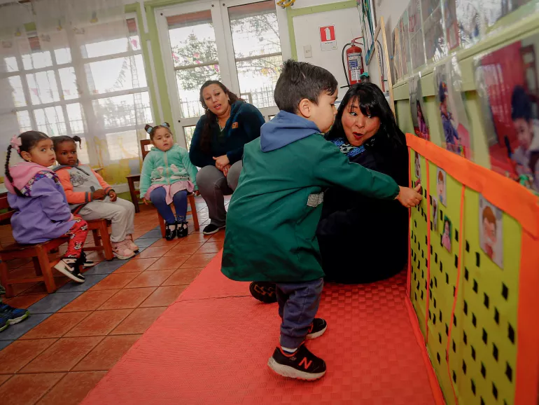 Ni&ntilde;o est&aacute; tocando un panel de corcho en una actividad escolar