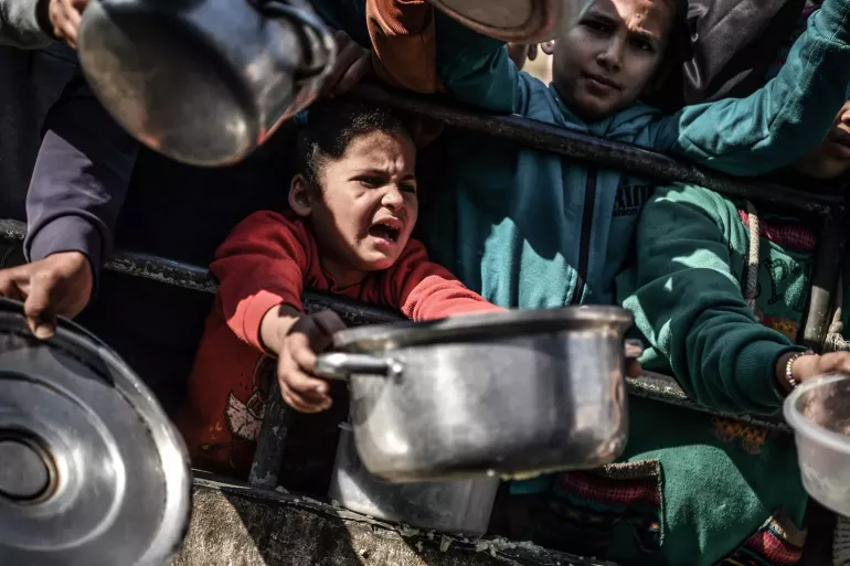 ni&ntilde;o con una olla entre las manos pidiendo comida