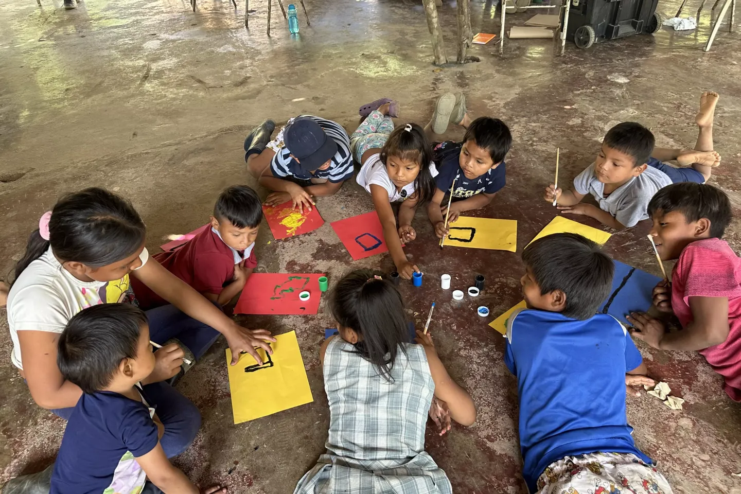 Ni&ntilde;as y ni&ntilde;os del pueblo Bar&iacute; dibujan en el piso 