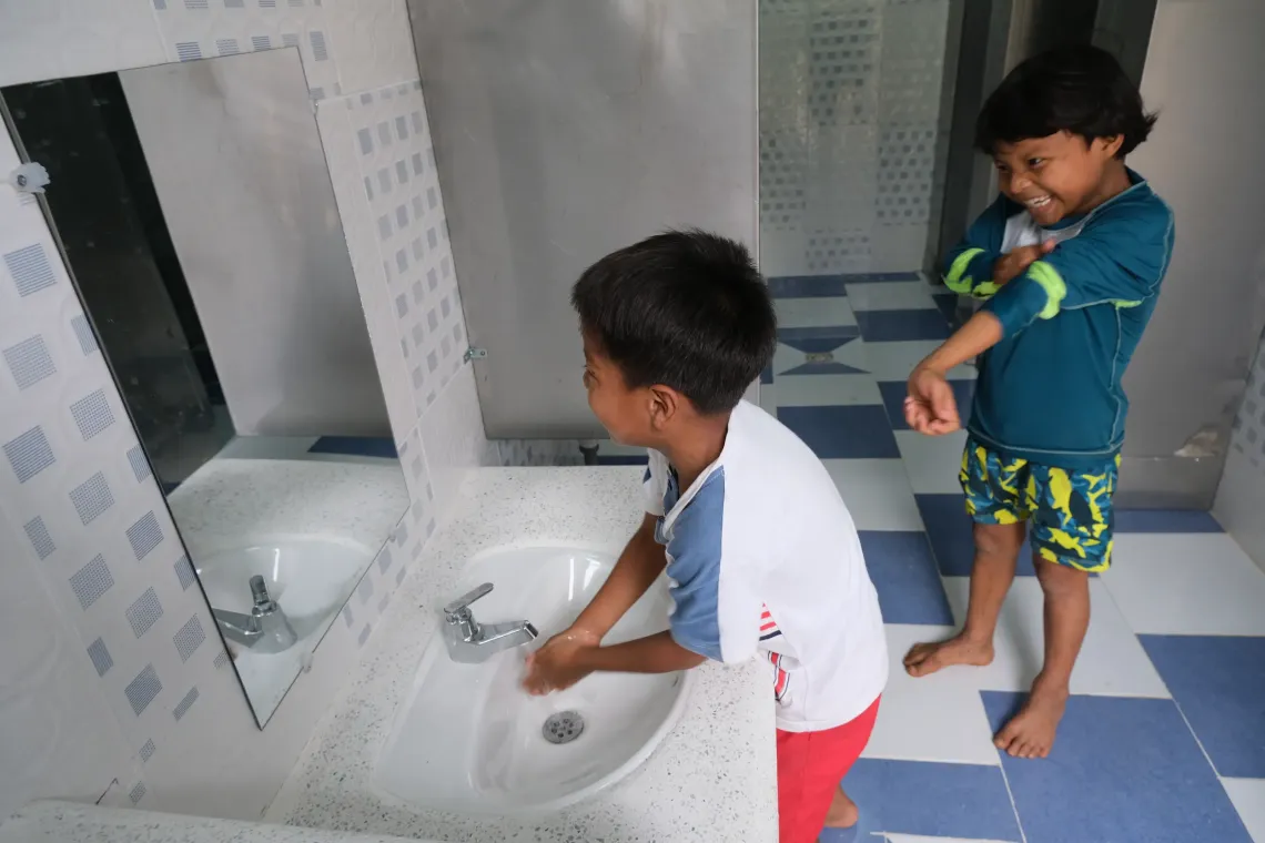 Ni&ntilde;os lav&aacute;ndose las manos en un ba&ntilde;o instalado por UNICEF.