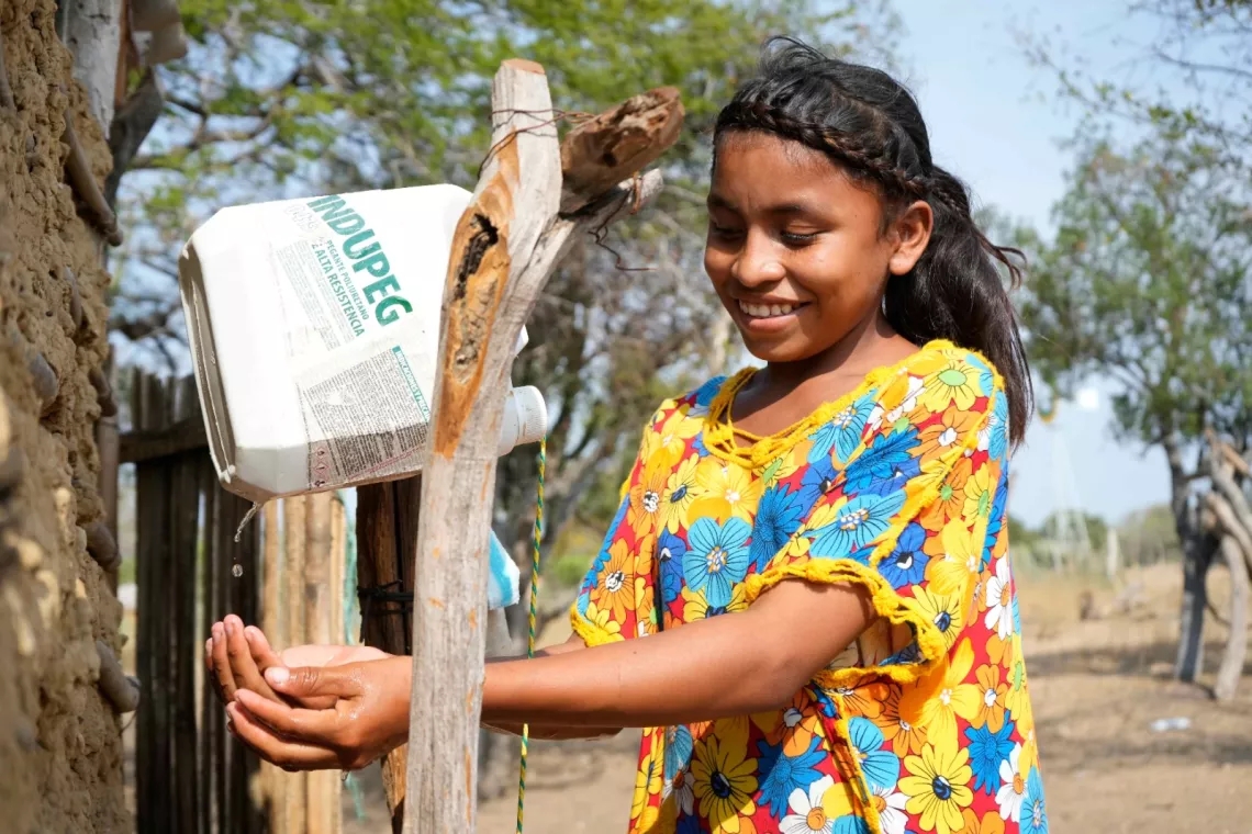 Ni&ntilde;a indigena lav&aacute;ndose las manos