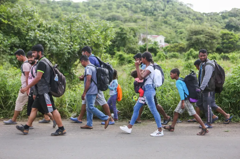 Un grupo de migrantes camina por la v&iacute;a que conduce desde El Pescadero a Tegucigalpa, capital de Honduras.