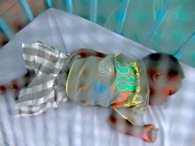 un enfant qui dors dans une moustiquaire