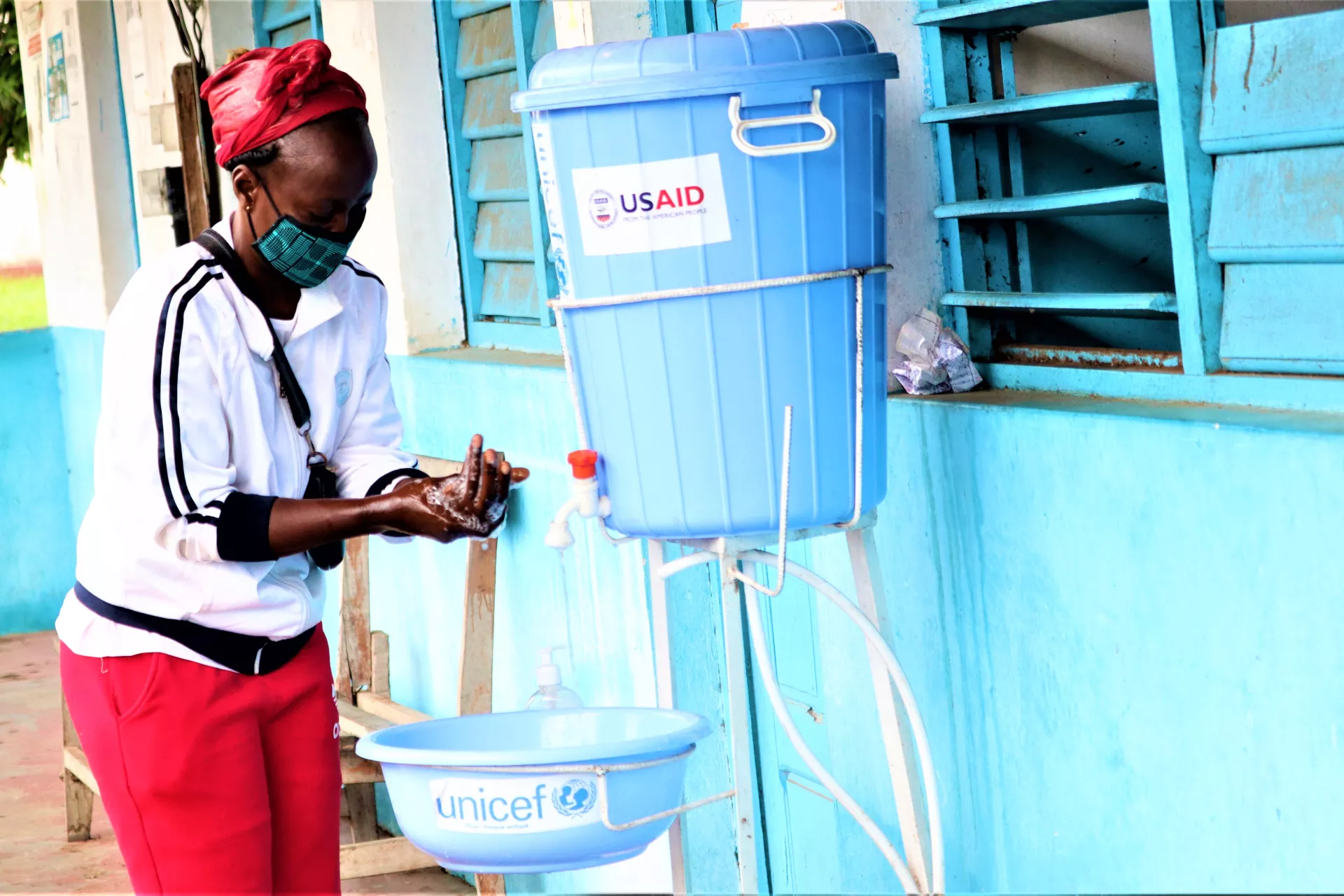 A patient washes her hands before entering the integrated health centre in Ngabe village, Pool department