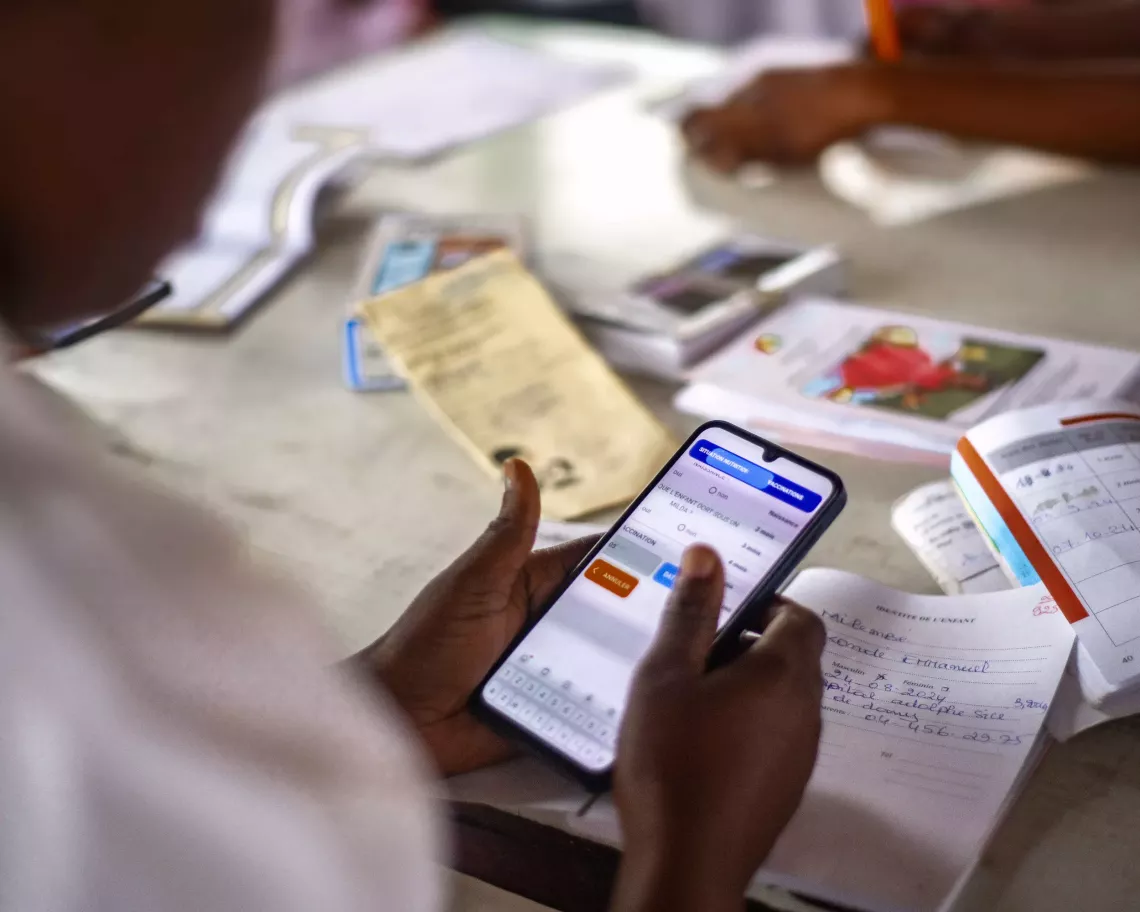 Une infirmi&egrave;re enregistrant un enfant dans l&rsquo;application MANGWELE 