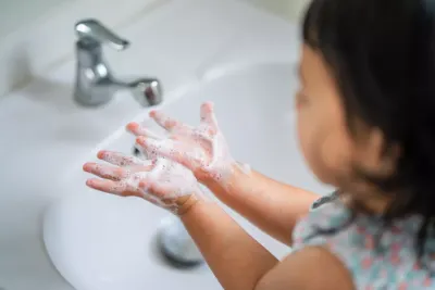 Ni&ntilde;a lavandose las manos