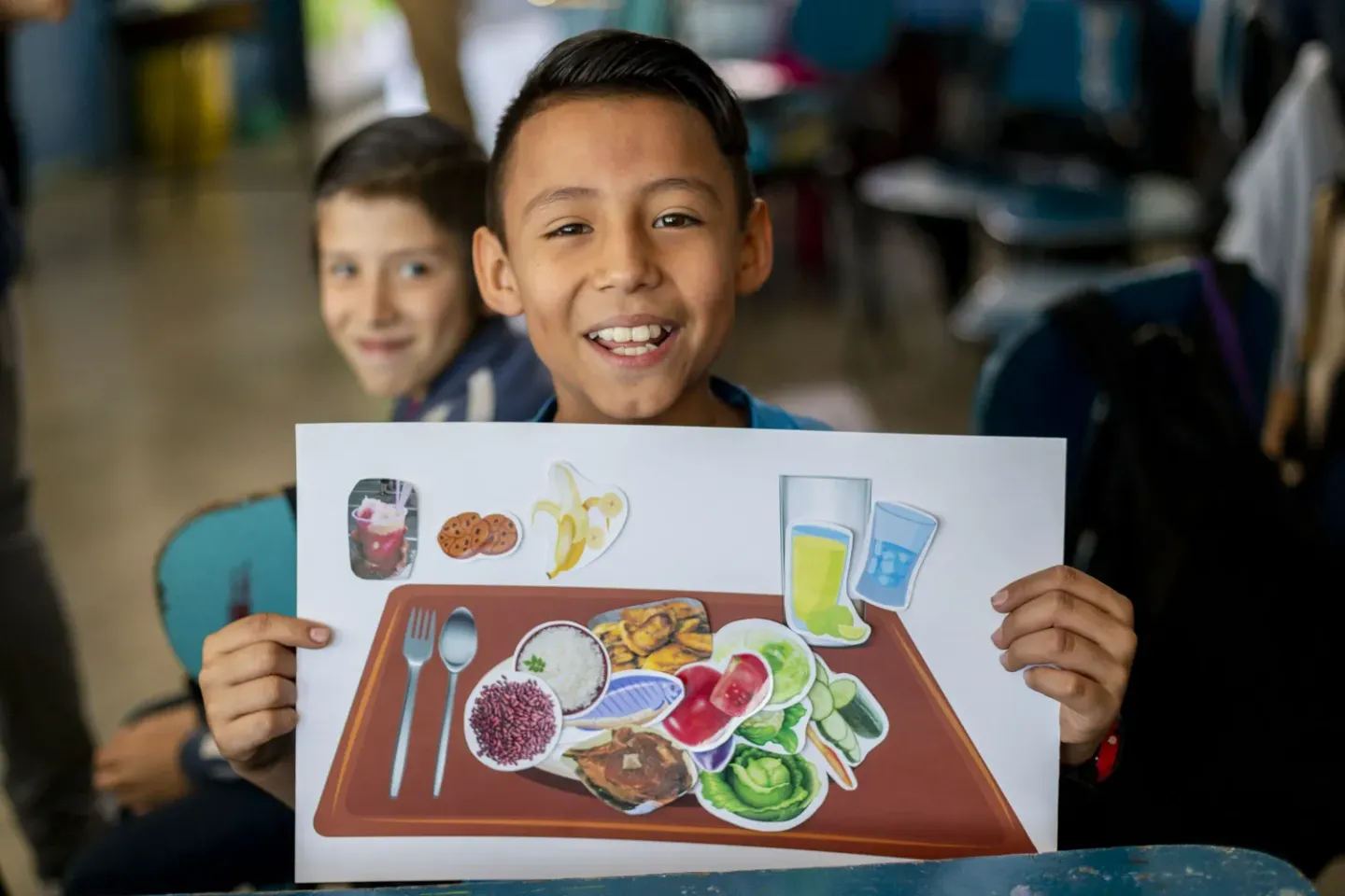Ni&ntilde;o sonriente con cartel nutrici&oacute;n