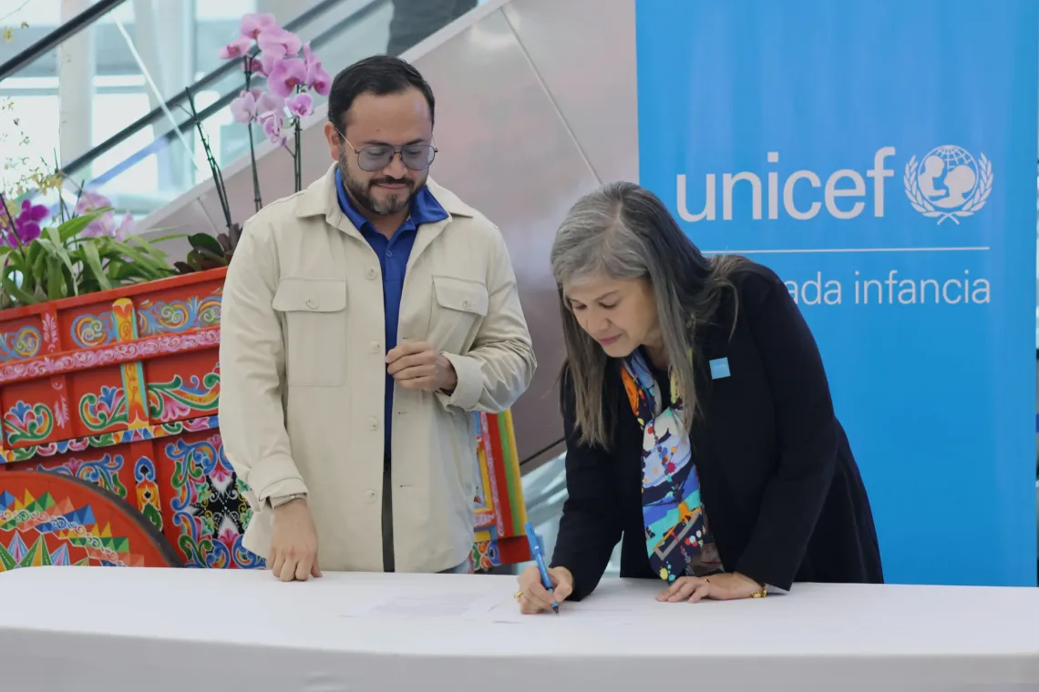 La representante de UNICEF en Costa Rica, Yvette Blanco, firma el convenio con su contraparte de AERIS.