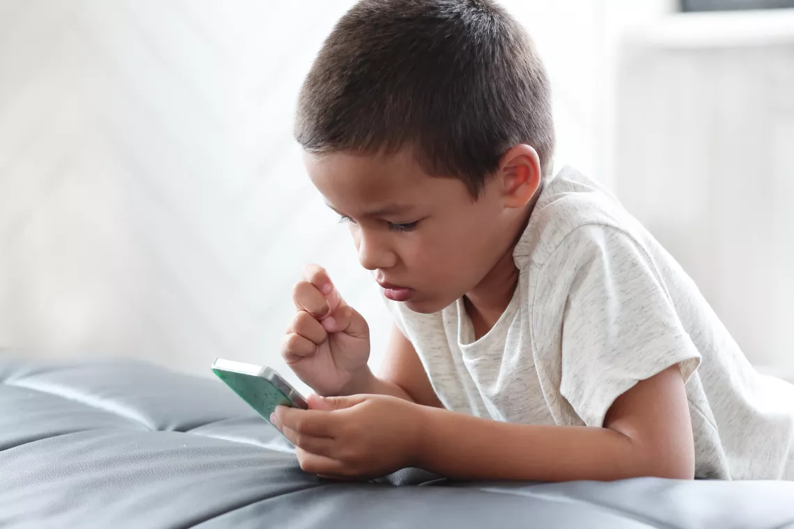 Ni&ntilde;o usando celular