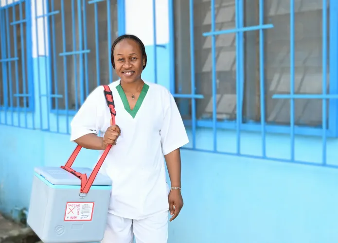 Sylvia Akabla, auxiliaire en soins obst&eacute;tricaux, portant le Porte-Vaccins