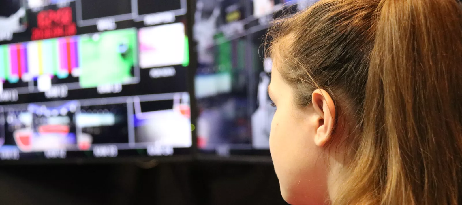 Mlada djevojka koja gleda puno TV ekrana