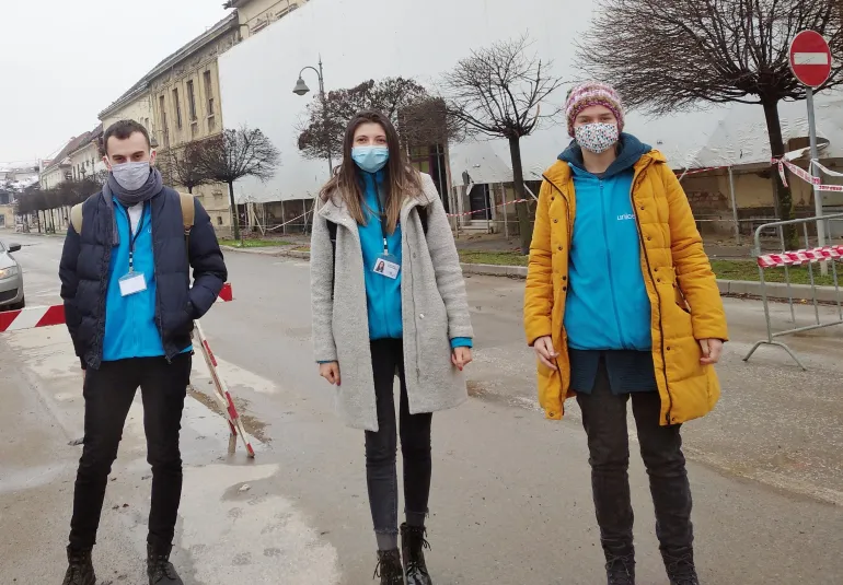 Three psychologists in UNICEF t-shirts standing in the street