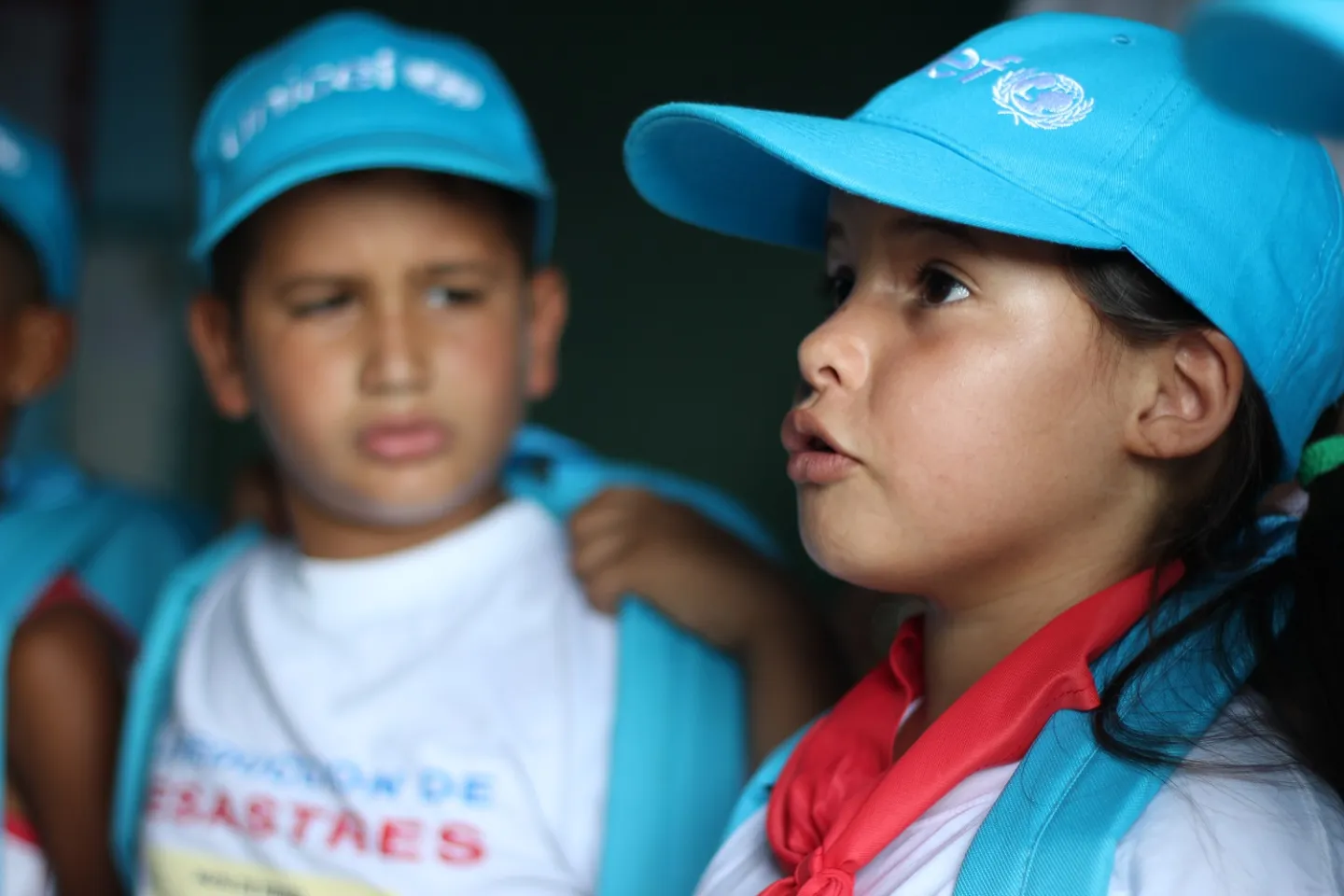 Dos ni&ntilde;os con gorras de UNICEF hablando