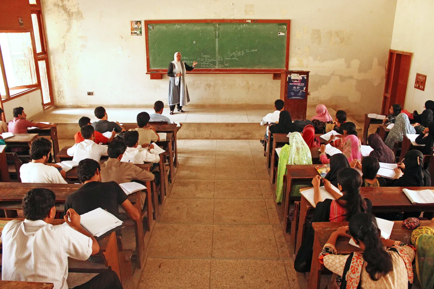 Teacher writing on chalkboard